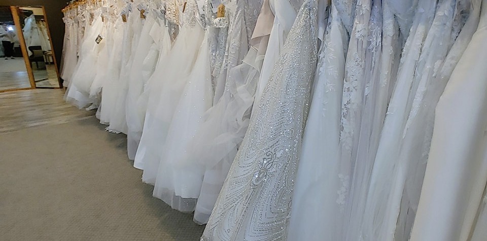 A long rack of white dresses