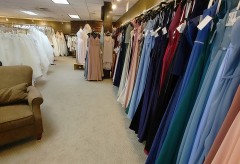 View of many long floor-length dresses both white and different colors