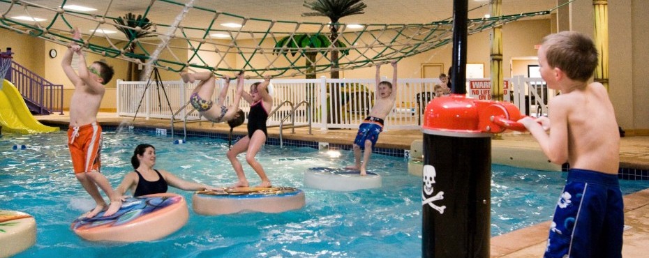 Children climbing across floating circles in the water playland